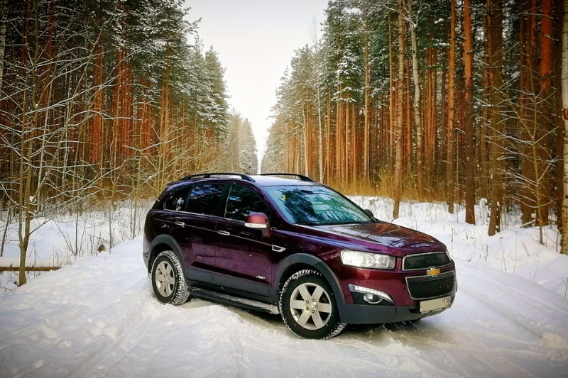  A car equipped for winter driving with snow tires and de-icer being used on the windshield