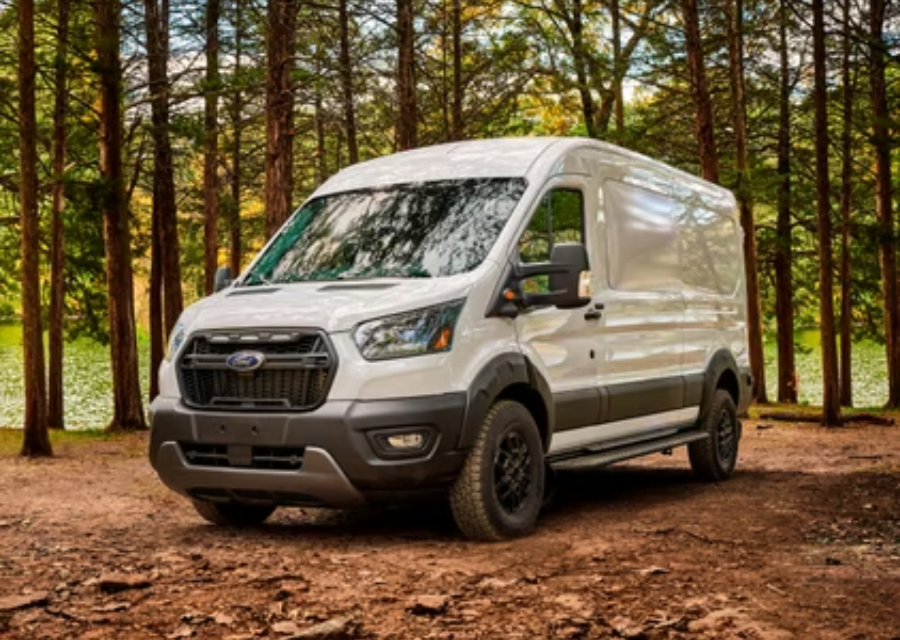 Ford Transit Trail Camper Van parked at a scenic campsite surrounded by nature.